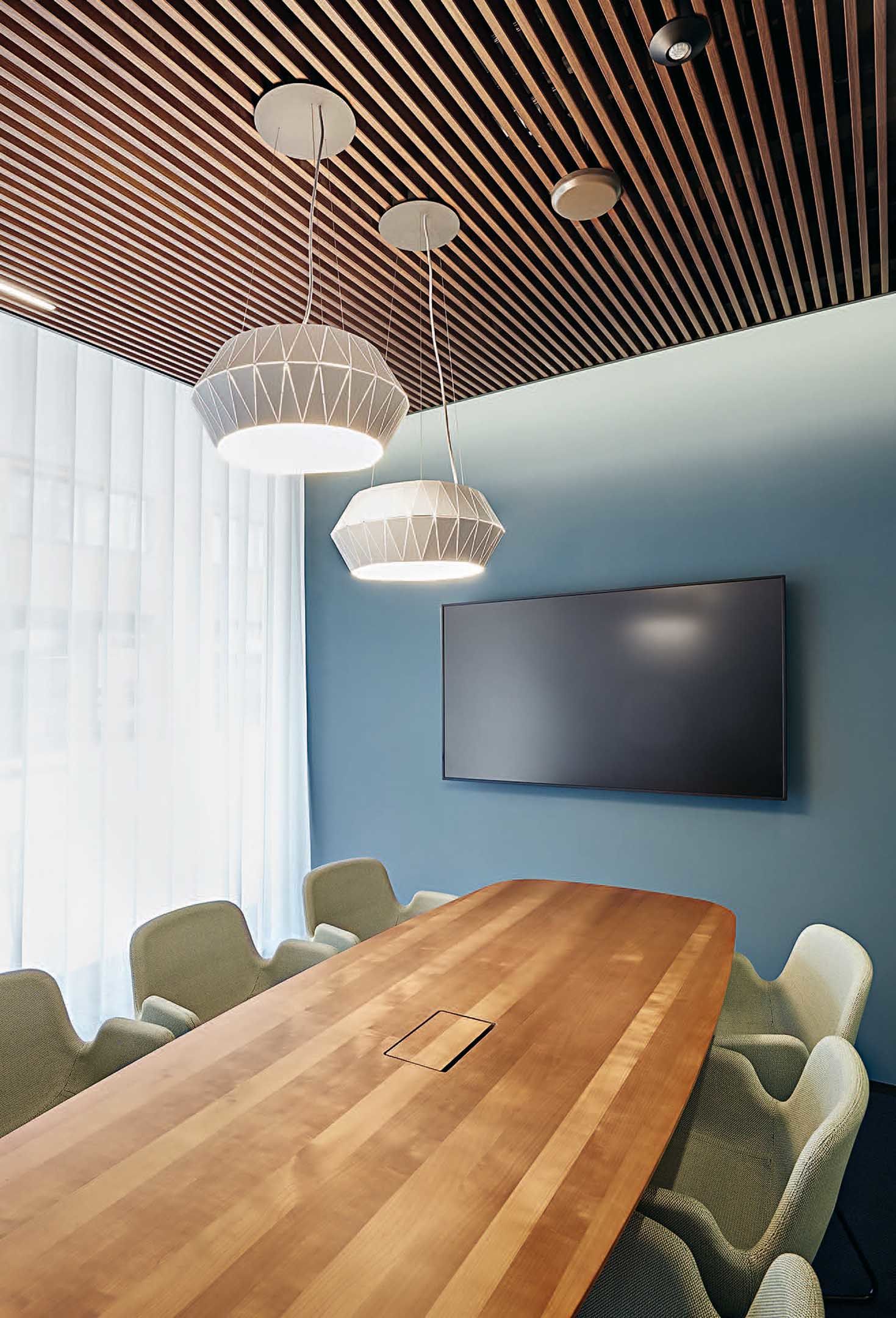 Die blaue Wand im stilvoll eingerichteten Kundenbesprechungszimmer nimmt Bezug auf die Zuger Seen und Flüsse. Die Gehri AG zeichnet für die Neugestaltung der Geschäftsstelle der Zuger Kantonalbank in Rotkreuz verantwortlich. Sie haben das Corporate Interior entwickelt und werden zusammen mit der Alfred Müller AG noch vier weitere Geschäftsstellen mit dem neuen Look & Feel umsetzen.<br>Foto: Gehri AG