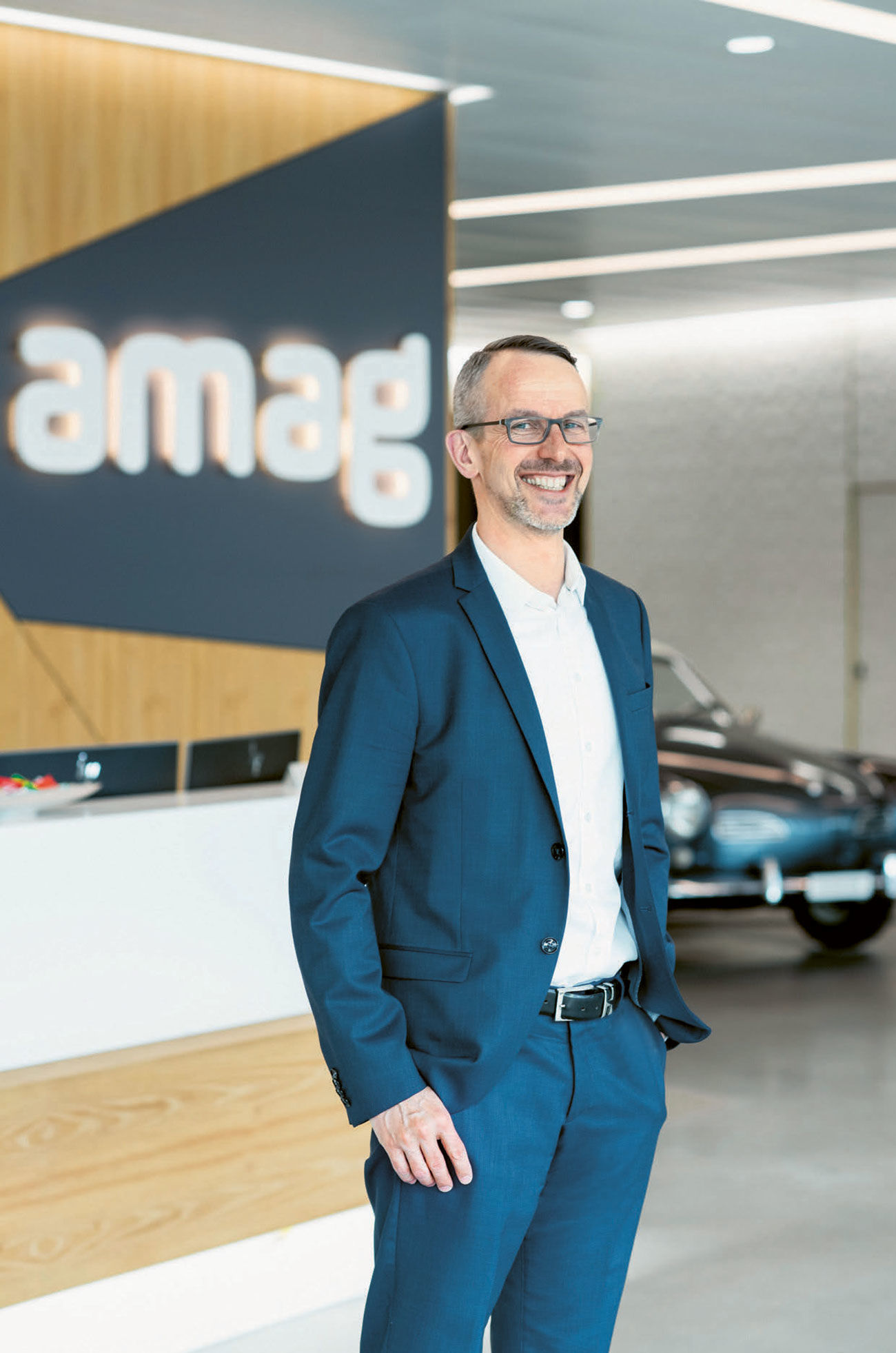 Les voitures sont omniprésentes au niveau siège d’AMAG: Thomas Linder, responsable des biens immobiliers, devant un véhicule de collection de la marque VW.<br>Photo: Selina Meier