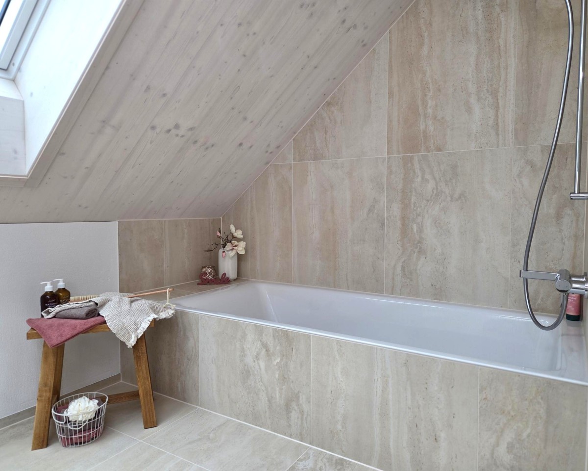 Edle, sandfarbene Wand- und Bodenplatten mit spannender Optik in den Nasszellen (Haus 2a)