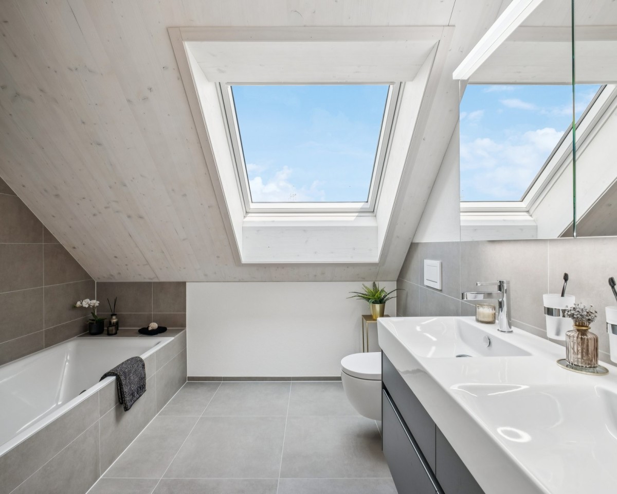 Grosszügige Nasszelle mit Badewanne und modernem Dusch-WC (Geberit AquaClean Alba)